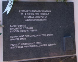 Placa conmemorativa de granito oscuro pulido situada en una pared clara. El texto, grabado en letras blancas mayúsculas, indica que se trata del lugar de descanso de restos exhumados de una fosa de la Guerra Civil Española por la Asociación Rebellar.

Incluye los siguientes datos forenses del individuo:

Edad: Entre 17 y 19 años.

Estatura: Entre 167 y 169 cm.

En la parte central figura una cita de Mahatma Gandhi: "No hay camino para la paz, la paz es el camino". La parte inferior menciona que el proyecto fue subvencionado por el Ministerio de Presidencia del Gobierno de España. 
