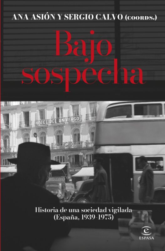 La portada del libro 'Bajo sospecha' tiene un diseño en blanco y negro y rojo. En la parte superior, los nombres 'ANA ASIÓN Y SERGIO CALVO (COORDS.)' están escritos en letras blancas. Debajo, el título 'Bajo sospecha' aparece en letras rojas grandes sobre un fondo oscuro. La mayor parte de la portada es una fotografía en blanco y negro que muestra una escena callejera vintage, con un hombre de espaldas en primer plano que parece observar la calle. Se puede ver un edificio con un letrero que dice 'HOTEL DEL UNIVERSO' y un autobús de dos pisos. En la parte inferior, el subtítulo 'Historia de una sociedad vigilada (España, 1939-1975)' está escrito en letras blancas. Debajo, el logo de la editorial 'ESPASA' está en blanco.